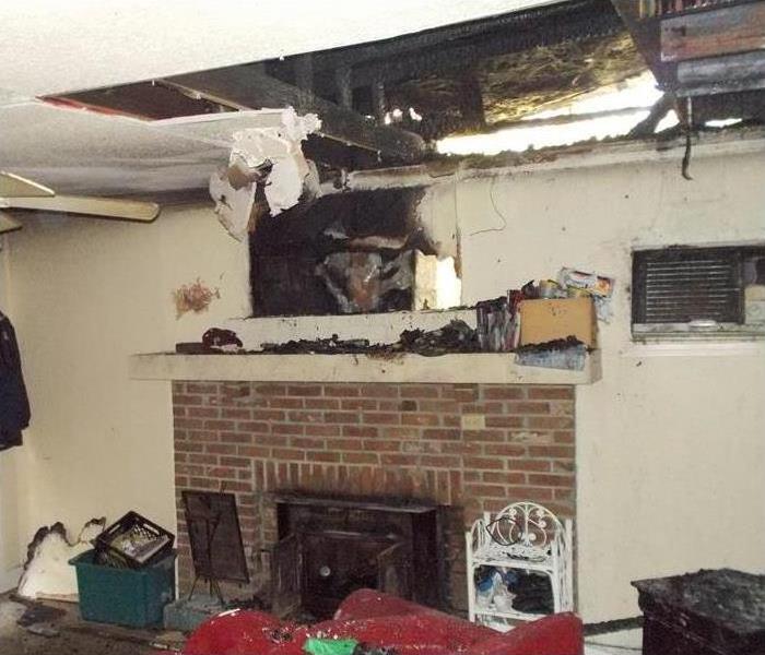 Fireplace with fire damage and exposed ceiling area