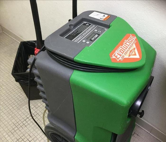 a green and gray dehumidifier in a restroom